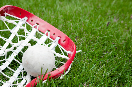 Boys & Girls lacrosse head and grey ball on grass